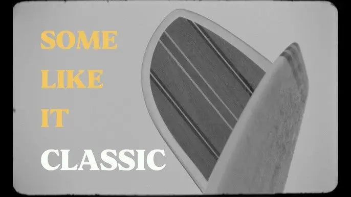 Shapers-Club- L'aileron arrière d'une planche de surf avec un motif en bois est représenté en noir et blanc. Le texte jaune et blanc indique « SHAPERS CLUB : SOME LIKE IT CLASSIC », évoquant un sentiment de style intemporel. -surfshop-surfboard