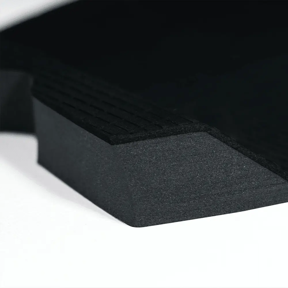 Shapers-Club- Gros plan du FUTURE - F2P WILDCAT, un objet triangulaire noir et texturé posé sur une surface blanche. Ses crêtes surélevées et ses bords tranchants évoquent la furtivité d'un chat sauvage, l'image mettant en valeur ses détails de matériau et de conception. -surfshop-surfboard