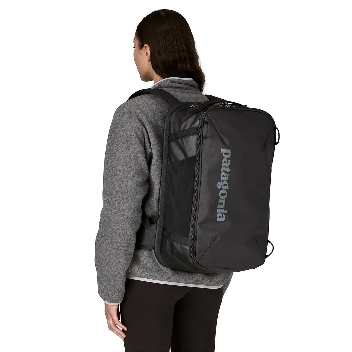 Femme portant un sac à dos noir Patagonia Black Hole Mini MLC de Surfshop - Shapers Club House sur le dos
