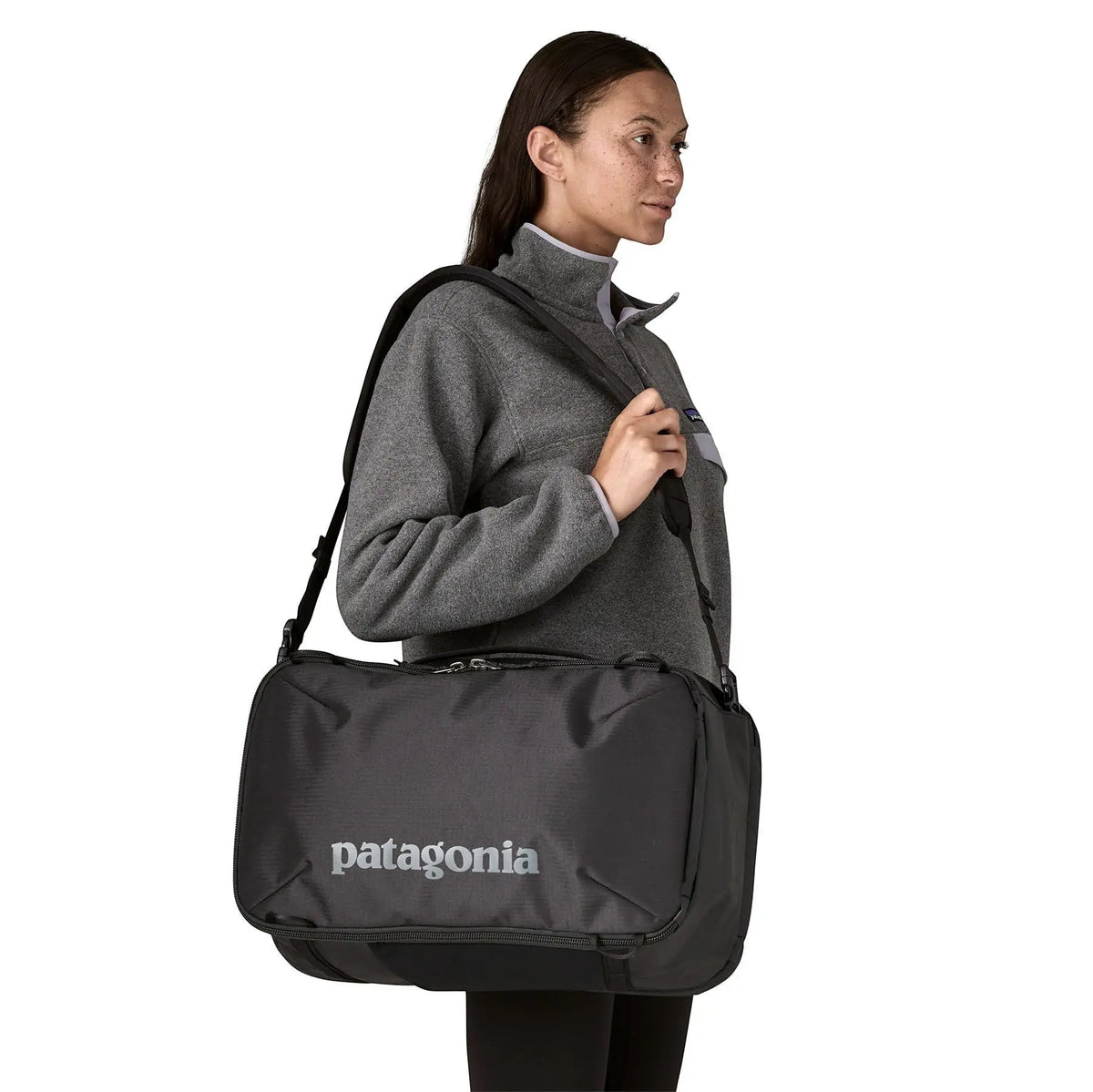 Femme portant le sac à dos noir Patagonia Black Hole Mini MLC de Surfshop - Shapers Club House sur l'épaule