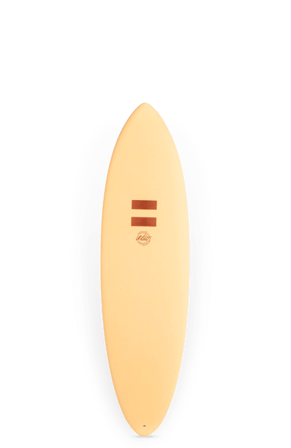 Shapers-Club- Planche de surf INDIO ULTRA Endurance RACER 6'0 de couleur sable avec le nom de la marque « Indio » au centre et deux lignes rouge-brun parallèles au-dessus. La planche de surf, qui incarne l'endurance et la vitesse comme une Endurance RACER, a une forme arrondie et profilée et est présentée verticalement sur un fond uni. -surfshop-surfboard