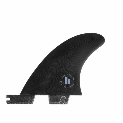 Shapers-Club- L'aileron arrière latéral FCS II - Carver - Quad en noir (Noir), fabriqué en verre PG Performance, présente une surface texturée et un petit emblème rond avec un texte flou. Cet aileron est doté d'une base rainurée pour la fixation et sa forme légèrement incurvée et profilée est conçue pour des performances hydrodynamiques optimales. Le fond est blanc. -surfshop-surfboard