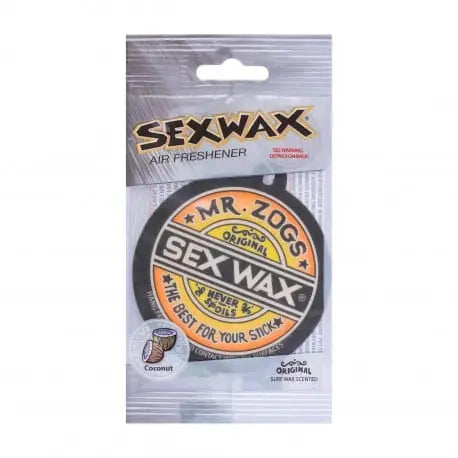 Shapers-Club- Le produit est un désodorisant parfumé à la noix de coco de marque « Sex Wax - Airfreshener » avec l'étiquette « Mr. Zog's Sex Wax » en caractères gras. L'emballage met en valeur des phrases telles que « The Best For Your Stick » et « Original ». Le désodorisant est livré dans un emballage transparent avec une languette de suspension sur le dessus pour une présentation facile. -surfshop-surfboard