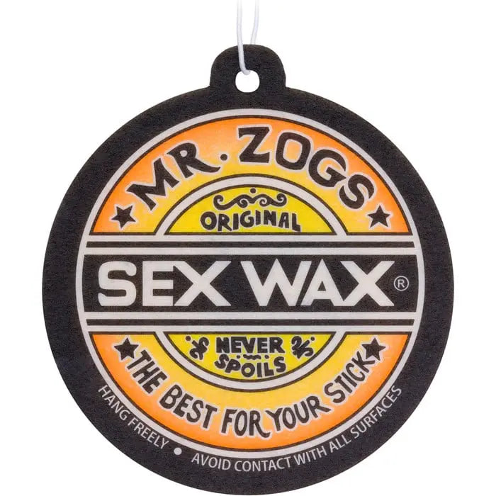 Shapers-Club- Un désodorisant rond « Sex Wax - Airfreshner » aux couleurs noir, blanc et orange conçu pour ressembler à une étiquette de cire de planche de surf « Mr. Zogs Sex Wax ». On peut y lire : « Mr. Zogs - Original - Désodorisant Sex Wax - Ne gâche jamais - Le meilleur pour votre bâton. -surfshop-surfboard