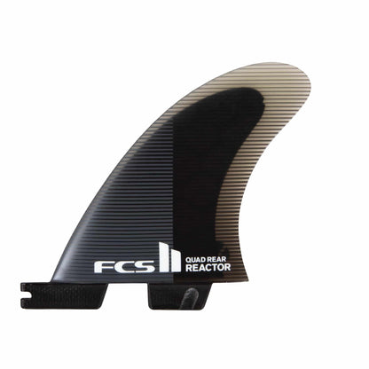 Shapers-Club- Gros plan d'un aileron de planche de surf noir étiqueté « FCS Ⅱ - REACTOR - QUAD REAR (Performance Core) ». L'aileron présente une partie supérieure légèrement translucide avec un motif rayé et une partie inférieure noire unie, parfaitement conçue pour s'intégrer dans un boîtier d'aileron de planche de surf. -surfshop-surfboard