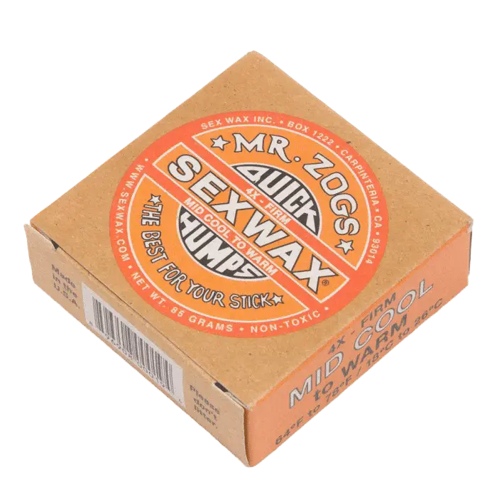 Shapers-Club- L'image présente une boîte orange de 85 g de Sexwax de M. Zog, étiquetée « Quick Humps », « Warm Tropical » et « The Best For Your Stick », conçue pour les planches de surf dans des conditions moyennement fraîches à chaudes. -surfshop-surfboard
