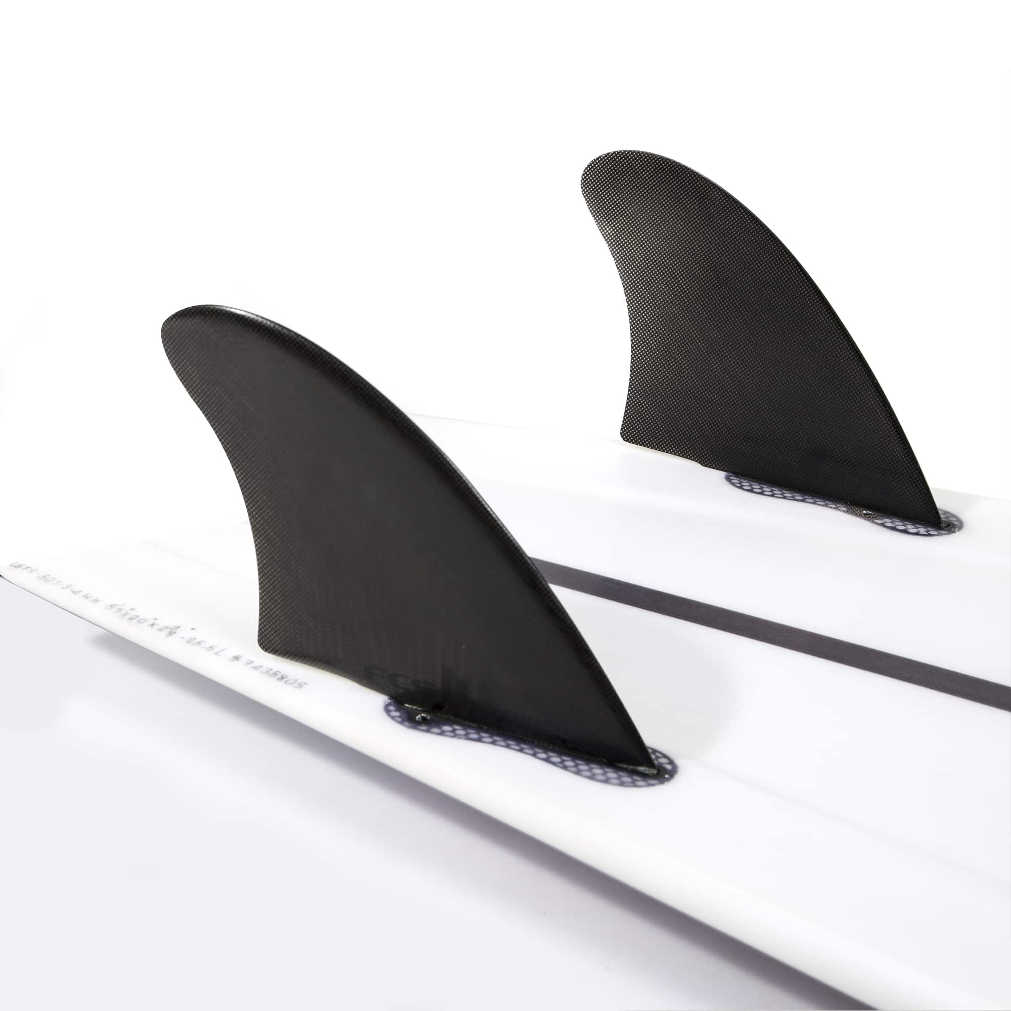 Shapers-Club- Gros plan d'une planche de surf blanche montrant deux ailerons noirs FCS Ⅱ - MODERN KEEL - TWIN fixés au fond, dotés de la technologie Performance Glass. L'arrière-plan est blanc uni, mettant en valeur le design élégant et la texture lisse de ces ailerons hautes performances. -surfshop-surfboard