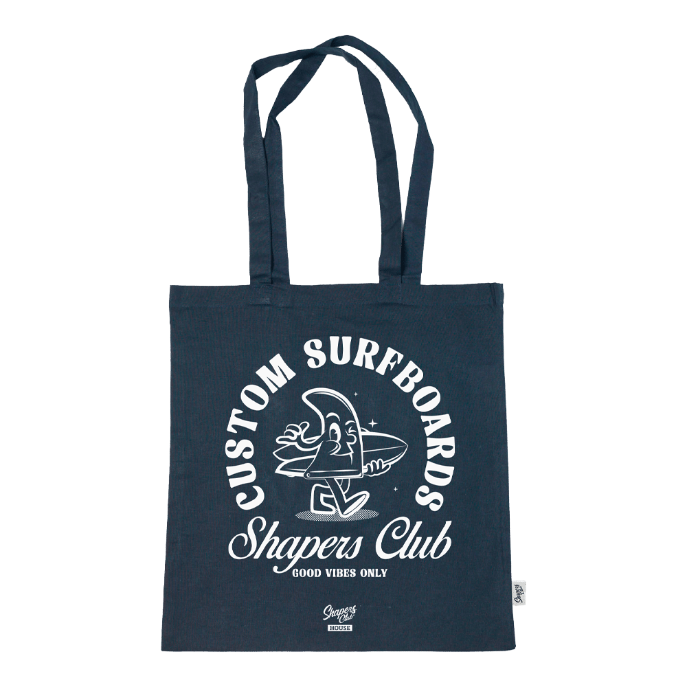 Shapers-Club- Présentation du sac fourre-tout - GOOD VIBES ONLY : ce sac fourre-tout bleu marine est orné de texte et de graphiques blancs, mettant en vedette un joyeux personnage de planche de surf de dessin animé avec les bras tendus. Entouré de la phrase « Custom Surfboards Shapers Club », il représente le mantra « Good Vibes Only ». Doté de longues poignées, ce sac est idéal pour transporter vos essentiels avec style. -surfshop-surfboard
