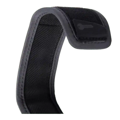 Shapers-Club- Gros plan d'une sangle en tissu noir du 6.0 COMP LEASH SURF GRIP, dotée d'une fermeture velcro et ressemblant à une leash de surf, légèrement courbée pour former une courbe sur fond blanc. Les bords sont renforcés pour une prise en main sûre, avec une petite languette visible à l'extrémité. -surfshop-surfboard