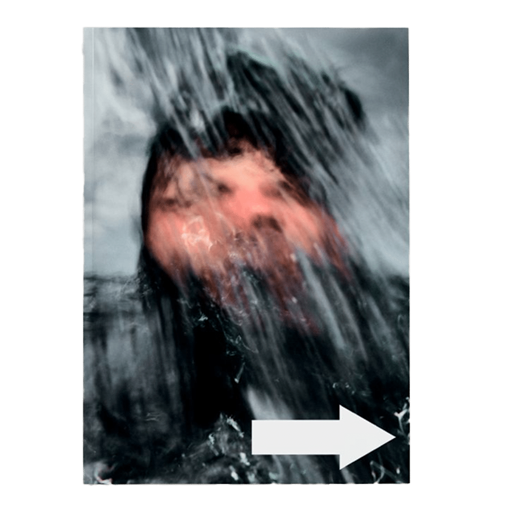 Shapers-Club- Un visage flou derrière une cascade d'eau capture l'excitation du surf, avec une flèche blanche vers la droite en dessous - une scène évocatrice d'ACID MAGAZINE - N°6 - WHATEVER SURFING MEANS. -surfshop-surfboard