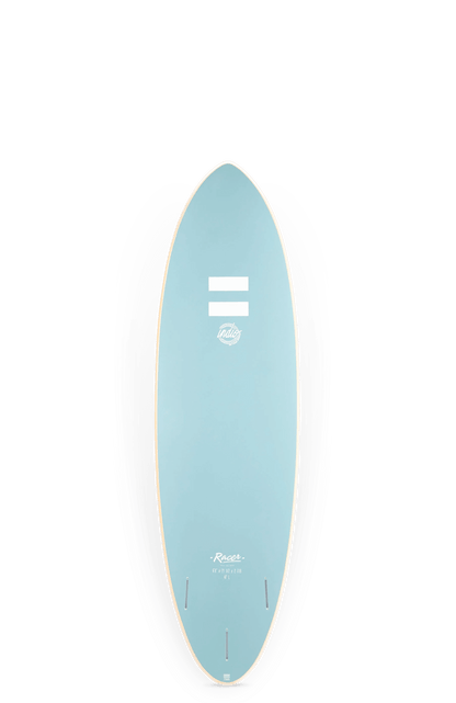 Shapers-Club- Image d'une planche de surf avec un dessus bleu pastel élégant et deux lignes horizontales blanches près de la pointe. Elle présente un design lisse et arrondi avec le nom de la marque « Rellie » et le modèle « Rensta » écrits près du bas. La planche, une INDIO ULTRA Endurance RACER 6'0 Sand, repose sur ses ailerons au milieu du sable mou. -surfshop-surfboard