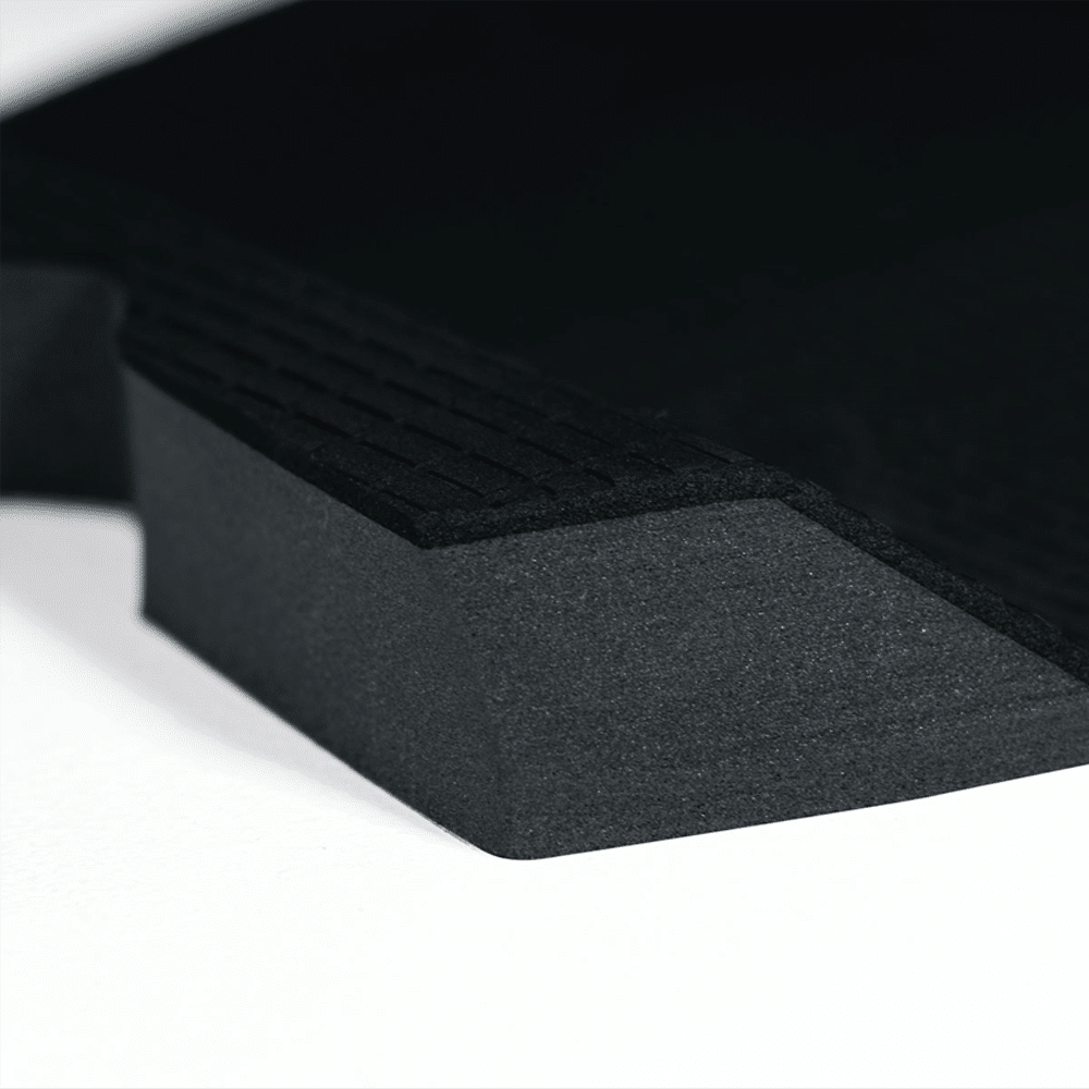 Shapers-Club- Gros plan du FUTURE - F2P WILDCAT, un objet triangulaire noir et texturé posé sur une surface blanche. Ses crêtes surélevées et ses bords tranchants évoquent la furtivité d'un chat sauvage, l'image mettant en valeur ses détails de matériau et de conception. -surfshop-surfboard