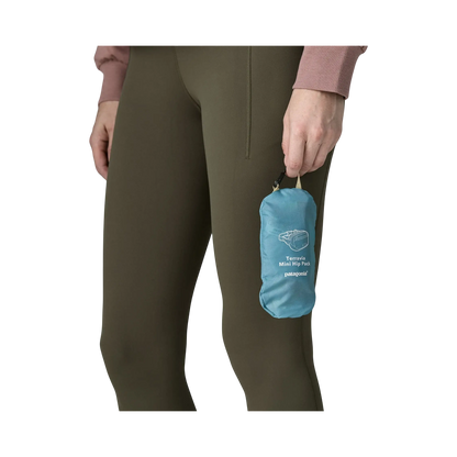 Sac banane bleu Patagonia Terravia Mini Hip Pack tenu à la main par une personne en legging kaki