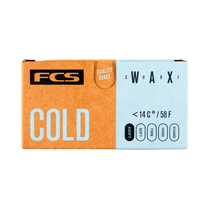 Shapers-Club- Une boîte rectangulaire de FCS - Cire - Froide étiquetée « FROID » en grandes lettres blanches sur fond bleu clair et marron. La boîte indique qu'elle convient aux températures inférieures à 14°C ou 58°F et comporte les mots « PERLES DE QUALITÉ » et « SWARXF ». -surfshop-surfboard
