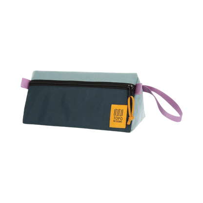 Shapers-Club- The TOPO toiletry bag in sage and pond blue is an elegant rectangular zippered pouch featuring a two-tone color palette, with a light blue top half and a dark navy bottom half. It features a black zipper closure, a purple loop handle, and a yellow square patch with the "TOPO" logo in a corner. -surfshop-surfboard