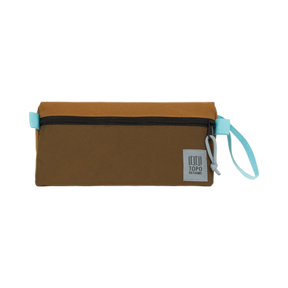 Shapers-Club- The TOPO toiletry kit in Desert Palm / Pond Blue is a rectangular bag with a zipper on the top. The top is light brown and the bottom is dark brown. It features a Pond Blue drawstring on the right side and a fabric label stating "TOPO DESIGNS" in the lower right corner. -surfshop-surfboard
