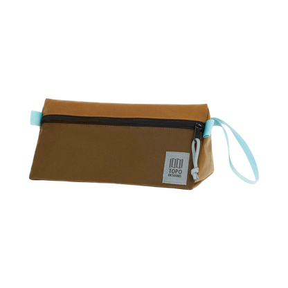 Shapers-Club- The TOPO toiletry bag in Desert Palm and Pond Blue is a rectangular pouch with a smooth fabric surface. It features a horizontal zipper closure on the top, a light blue drawstring reminiscent of Pond Blue attached on one side and a small gray label with text in the lower right corner. -surfshop-surfboard