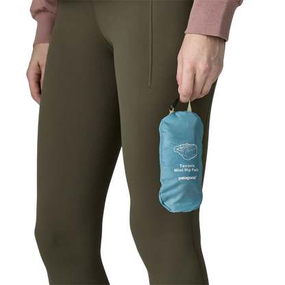 Sac banane bleu Patagonia Terravia Mini Hip Pack tenu à la main par une personne en legging kaki
