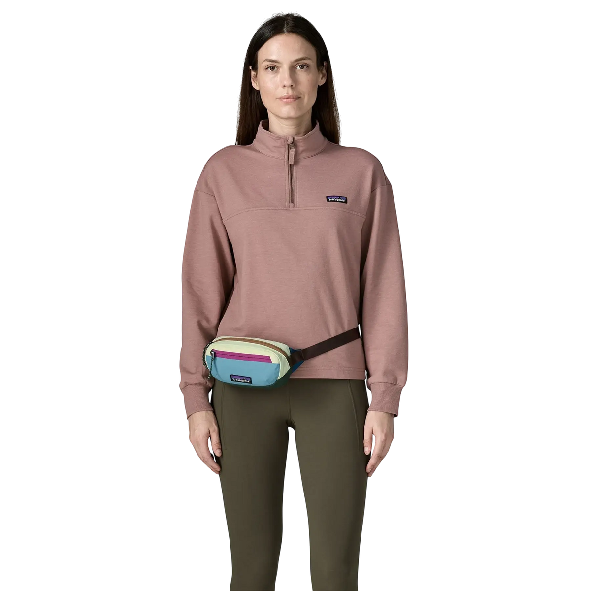 Sacoche banane Patagonia Terravia Mini Hip Pack multicolore portée par une femme avec un sweat rose